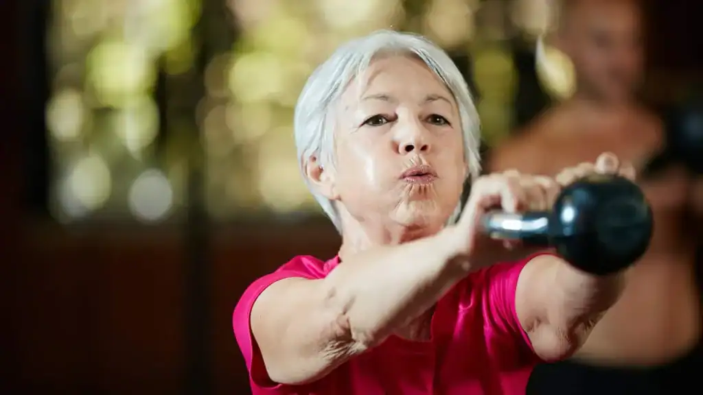 Toning Arms After 60: Empowering Womens Fitness Through Effective Weight Training 1 Older woman doing weight training Godalming to help her strength and longevity